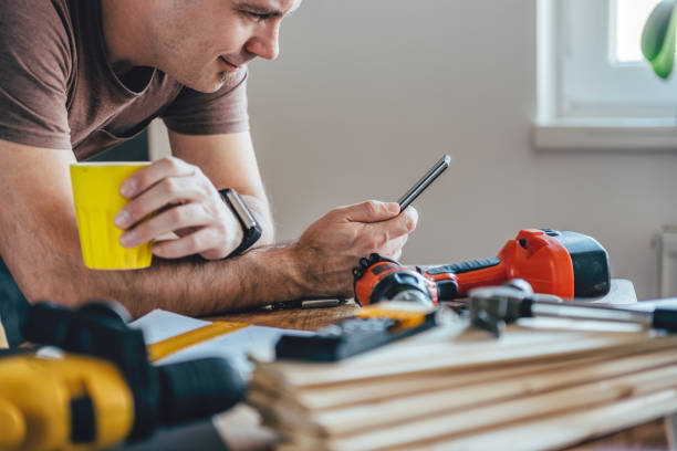 男はスマート フォンを使用し、一杯のコーヒー - carpenter construction residential structure construction worker ストックフォトと画像