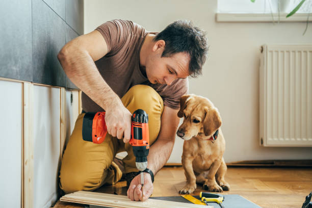 Man and his dog doing renovation work at home Man doing renovation work at home together with his small yellow dog home improvement stock pictures, royalty-free photos & images