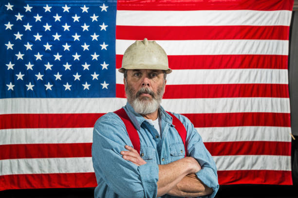 istock Middle-aged construction worker portrait in front of a US flag 668040478