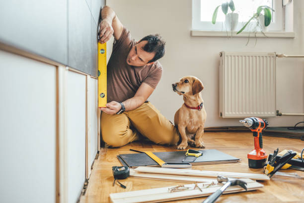 Man and his dog doing renovation work at home Man doing renovation work at home together with his small yellow dog home addition stock pictures, royalty-free photos & images