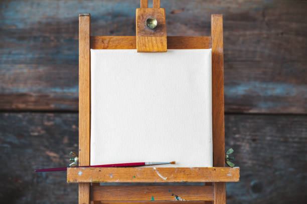 istock Empty canvas on easel on old wooden background. 668043950