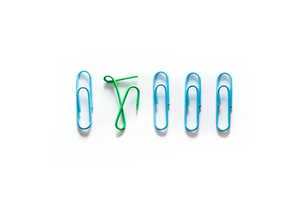 Unique paper clips concept with one clip bent to show difference