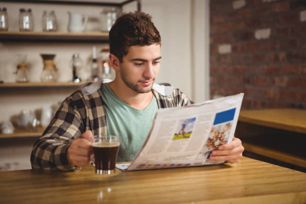 istock Hipster drinking coffee and reading newspaper 668050808