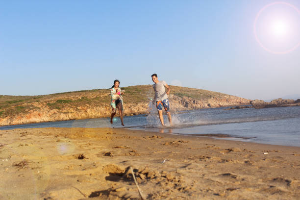 istock lovely couple having fun on the beach splashing 668050914