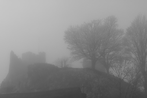 A photograph of a silhouetted Lewes Castle in the mist