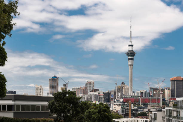 Auckland, New Zealand - March 1, 2017: From the higher lying Ponsonby Road, the Sky Tower can be seen clearly towering over the rest of the skyline with famous business names. White clouds in blue sky