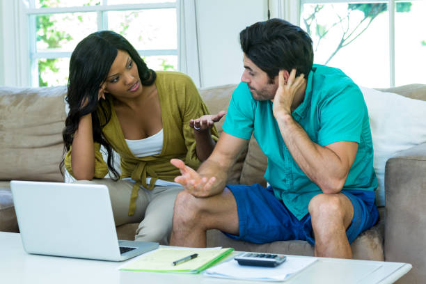 istock Worried young couple with laptop discussing on bills 668057122