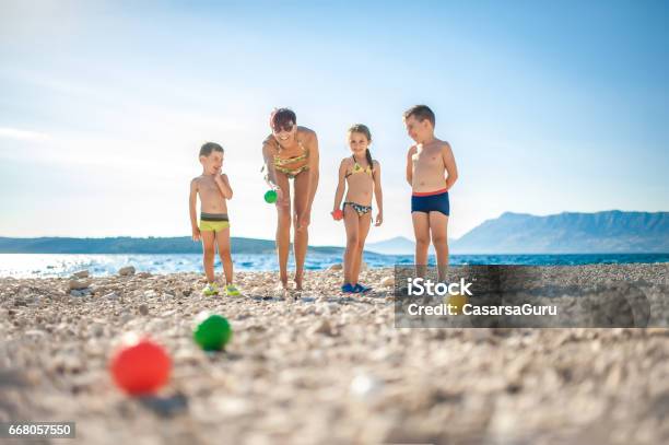 Mother Playing Boccia With Children On The Beach Stock Photo - Download Image Now - Boules, Pétanque, Child