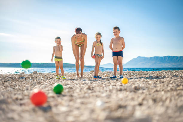 istock Mother Playing Boccia With Children On The Beach 668057560