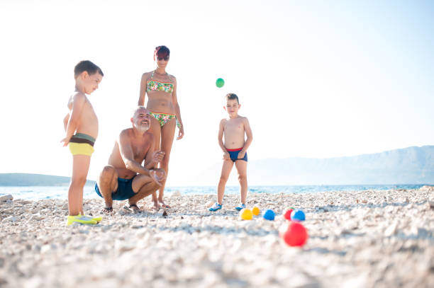 istock Mother Playing Boccia With Children On The Beach 668057576