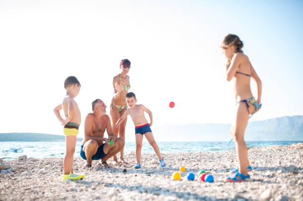 istock Mother Playing Boccia With Children On The Beach 668057580