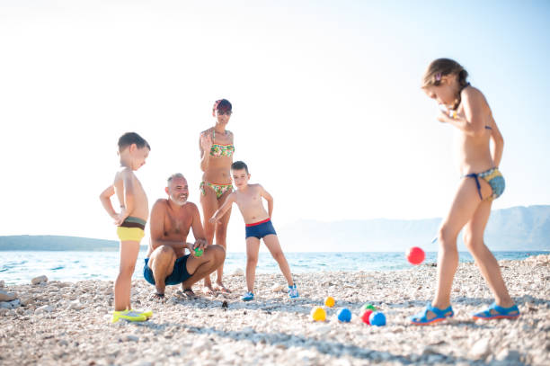 istock Mother Playing Boccia With Children On The Beach 668057594