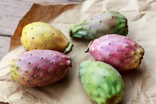 Edible Cactus Succulent (Opuntia ficus-barbarica), also known as prickly pears, prickly fig and chervil. Group of ripe yellow fruits in nature on a sunny day. Natural foods on sky background with copy space