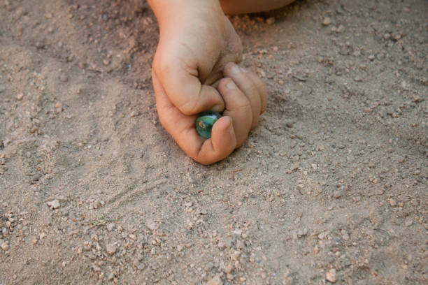 childhood with a hand shooting marbles