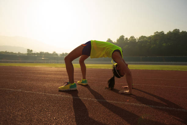 istock young asian woman backbending on stadium track 668064398