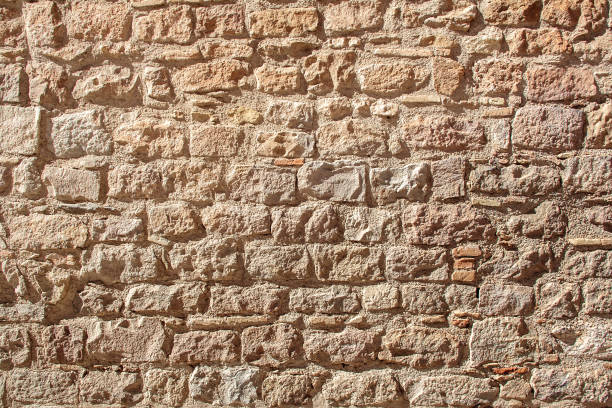 istock medieval stone wall of old building in sunny day 668067206