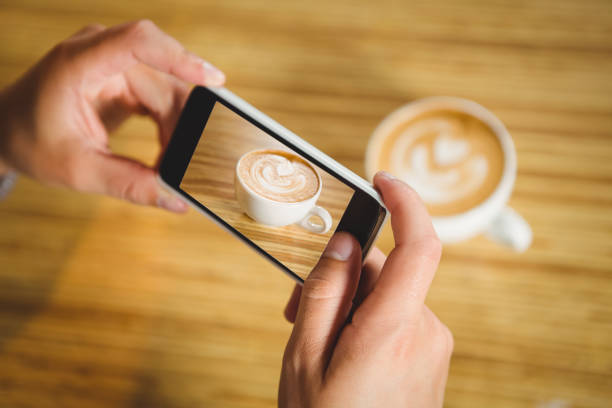 istock Man photographing his cappuccino with coffee art 668067212