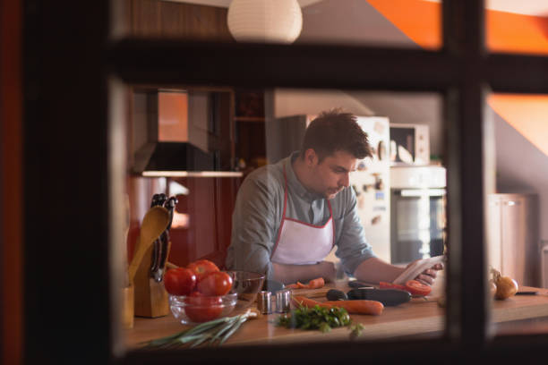 istock Young, handsome man cooking food in a kitchen 668070458