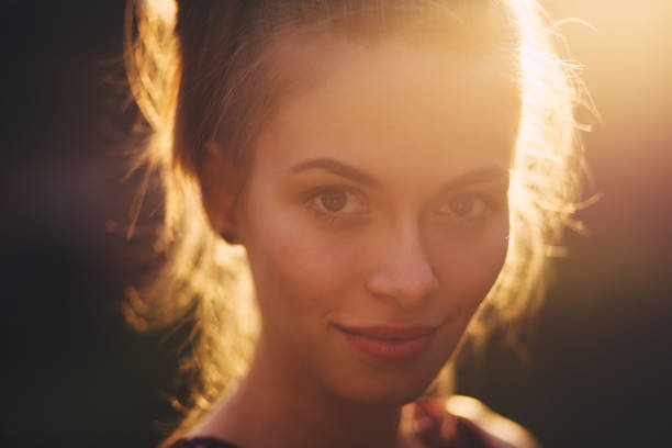 istock Beautiful young woman in the sunlight at sunset. 668070810