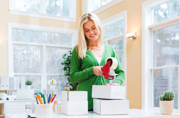 istock Young woman packing boxes to be shipped 668070958