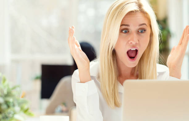 istock Surprised young woman sitting at her desk 668070962