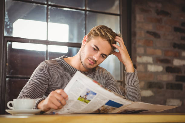 istock Handsome man having coffee and reading newspaper 668074510
