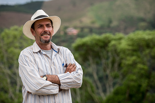 Portrait of a Colombian coffee farmer looking at the camera smiling at a farm - rural scene concepts