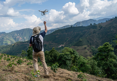 Casual man flying a drone in the countryside - photography concepts