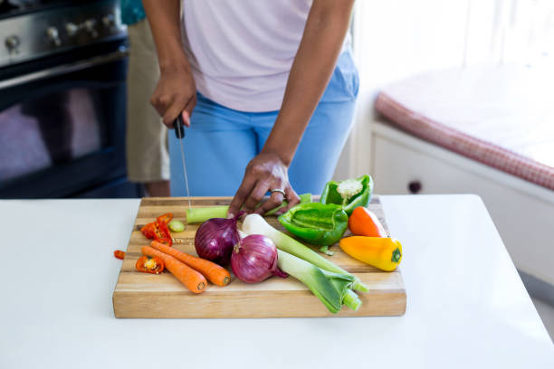 istock Mid-section of woman chopping vegetable in kitchen 668080802