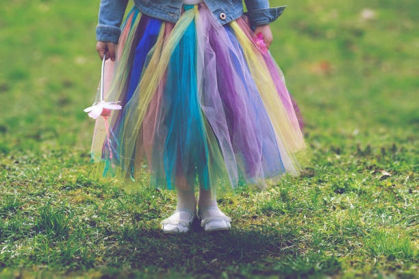 niña en la falda del tutú colorido sobre la verde hierba de pie sosteniendo la varita mágica - fairy child outdoors fairy tale fotografías e imágenes de stock
