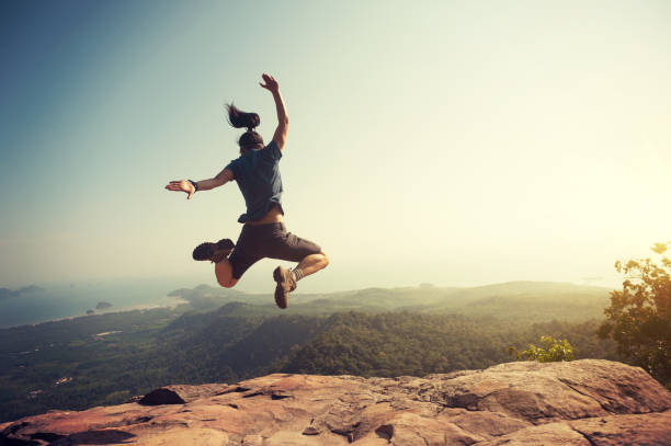 istock jumping on rocky mountain peak, freedom, risk, challenge, success concept 668086750