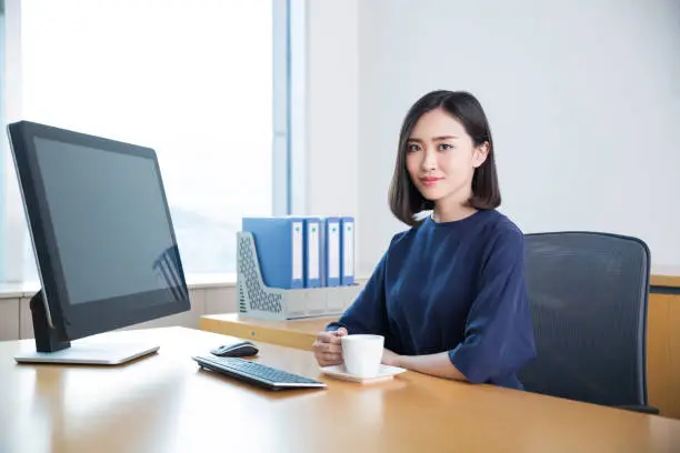 young beautiful girl,sitting in the office began her work