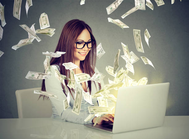 Professional smart young woman using a laptop building online business Professional smart young woman using a laptop building online business making money dollar bills cash coming out of computer. Beginner IT entrepreneur success economy concept making money online stock pictures, royalty-free photos & images