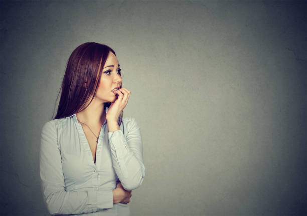 istock Preoccupied anxious young woman biting her fingernails 668087812
