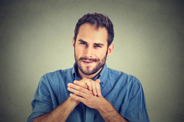 Sneaky scheming young man plotting something wants to screw someone Sneaky scheming young man, worker trying to plot something, screw someone isolated on gray wall background. Negative human emotion facial expression feeling attitude evil corporation stock pictures, royalty-free photos & images