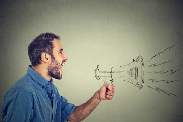 istock angry young man holding screaming in megaphone 668093410