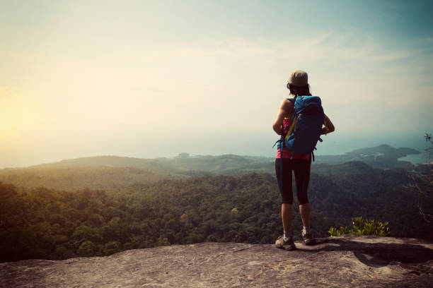 istock young woman backpacker enjoy the view on mountain peak 668093468