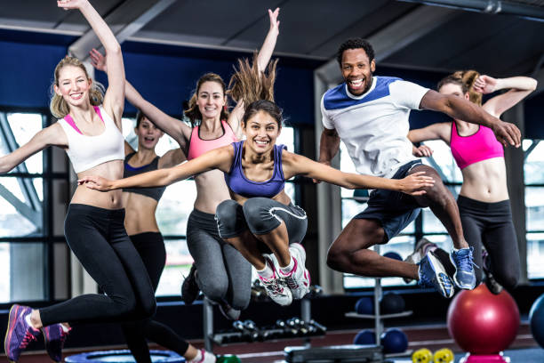 grupo fit sonriendo y saltando - healthy lifestyle women jumping happiness fotografías e imágenes de stock