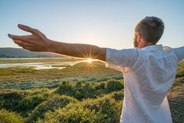 istock Young man relaxing by the sea, arms outstretched 668103232