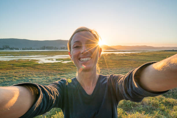 istock Young woman taking a selfie portrait at sunset 668104112