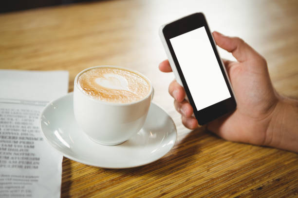 Young woman making picture from a coffee with smartphone.