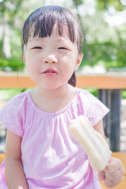 istock cute girl eat popsicle 668109698