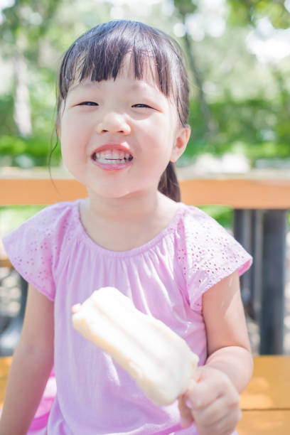 istock cute girl eat popsicle 668109728