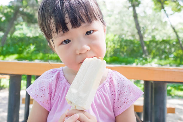 istock cute girl eat popsicle 668109758
