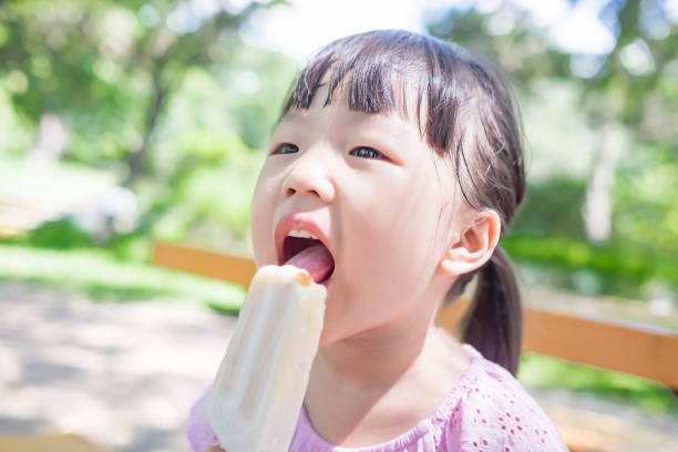 istock cute girl eat popsicle 668109798