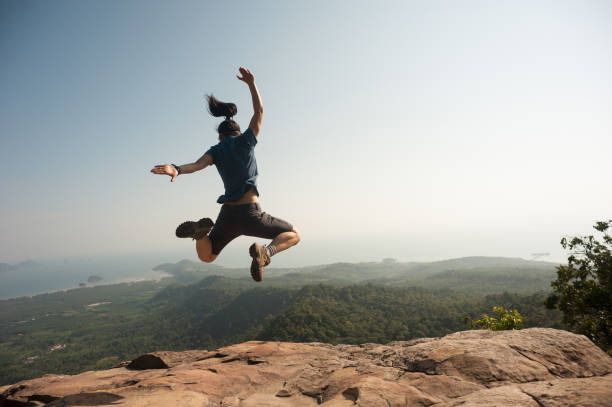 istock jumping on rocky mountain peak, freedom, risk, challenge, success concept 668110726