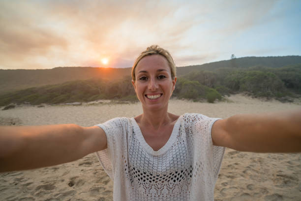 istock Young woman takes selfie on sand dunes 668113220