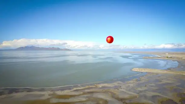 Lone red balloon floating high over the great salt lake