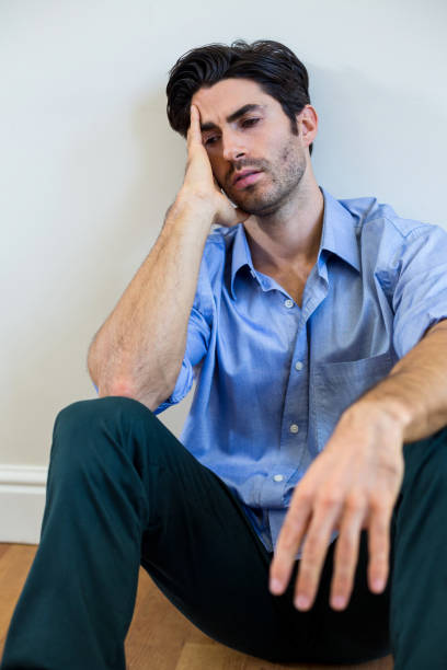 istock Depressed man with hand on forehead leaning against a wall 668127140