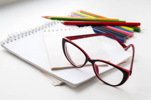 istock Red glasses on the notebook and colored pencils 668130318